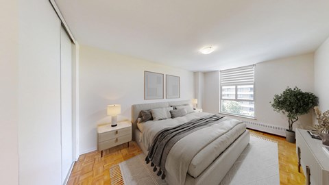 A bedroom with a large bed and a small nightstand with a lamp.